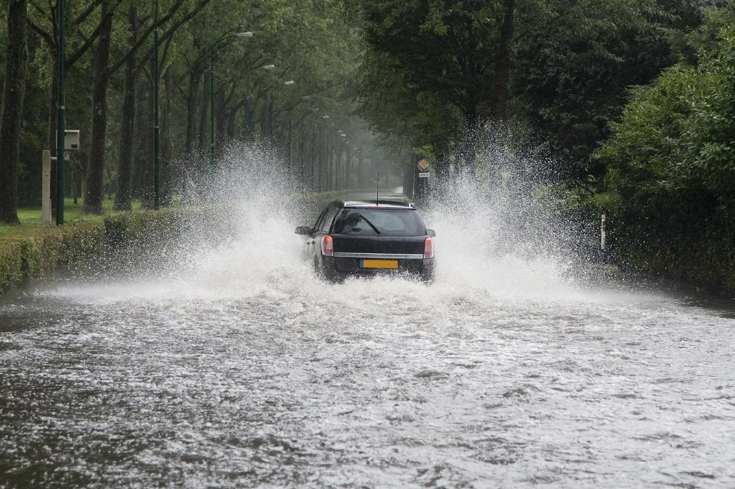 A car driving thorough a flooded street