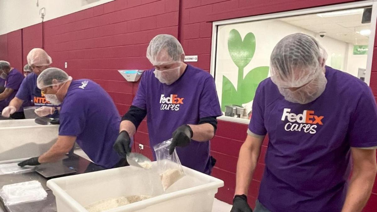 Several people wearing FedEx shirts preparing food at the Food Bank