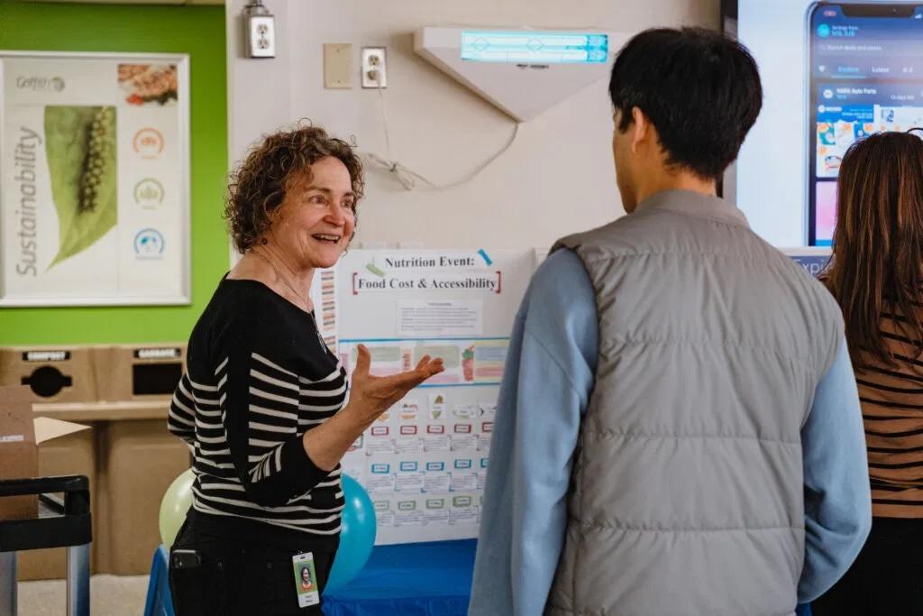 Two people discussing a chart labeled "Food Cost and Affordability"