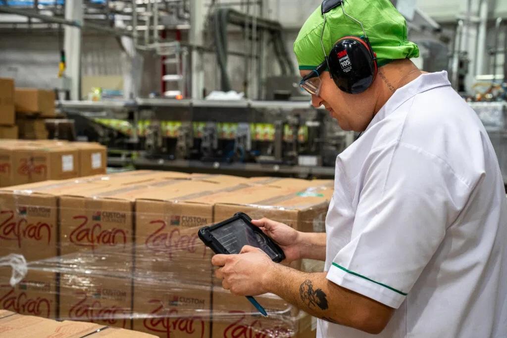 Person working in warehouse looking at tablet