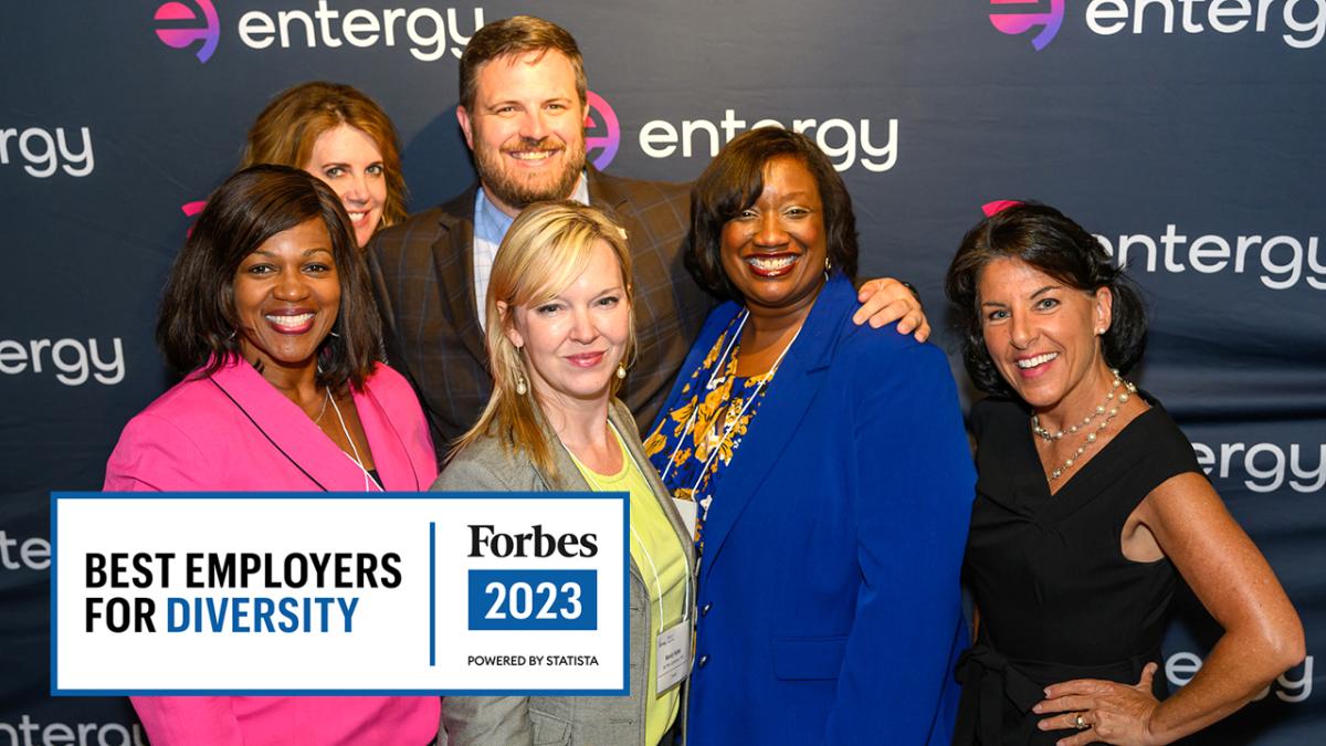6 people pose for a picture in front of an entergy backdrop