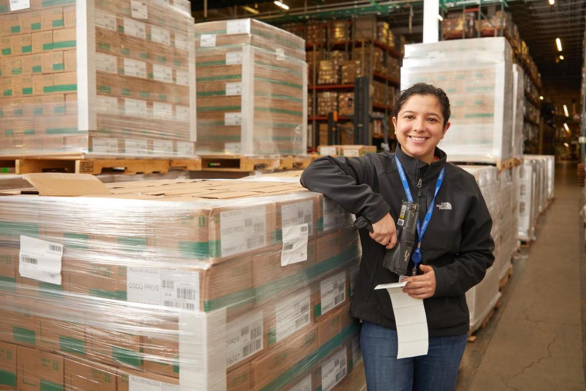 Bath & Body Works announces its inclusion on Forbes’ list of America's Best Employers for Women. person smiling next to a warehouse of boxes