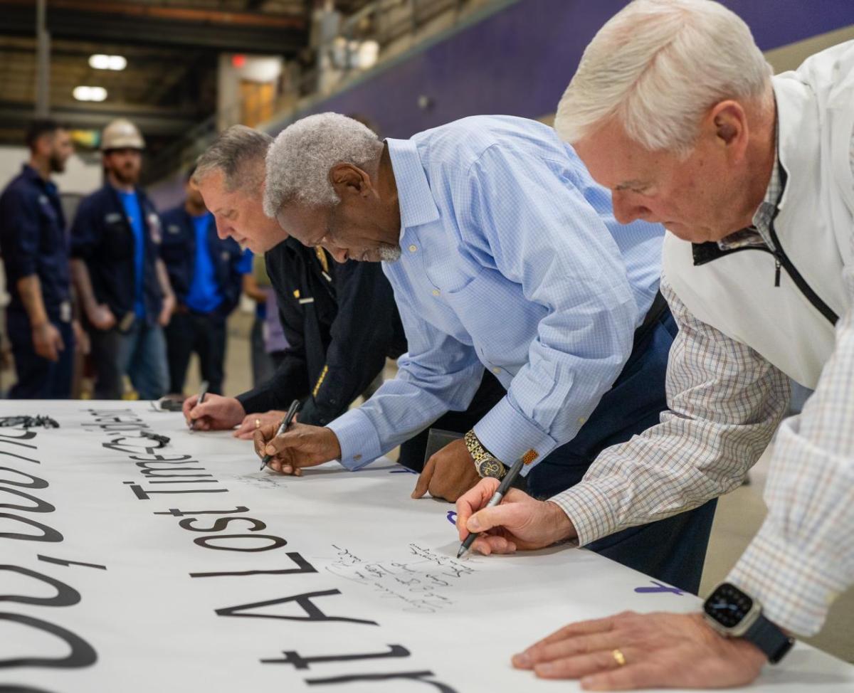 Fort Smith Police Chief Danny Baker, Fort Smith Mayor George McGill and Congressman Steve Womack sign a banner celebrating Trane Fort Smith achieving 5,000,000 hours without a lost time injury
