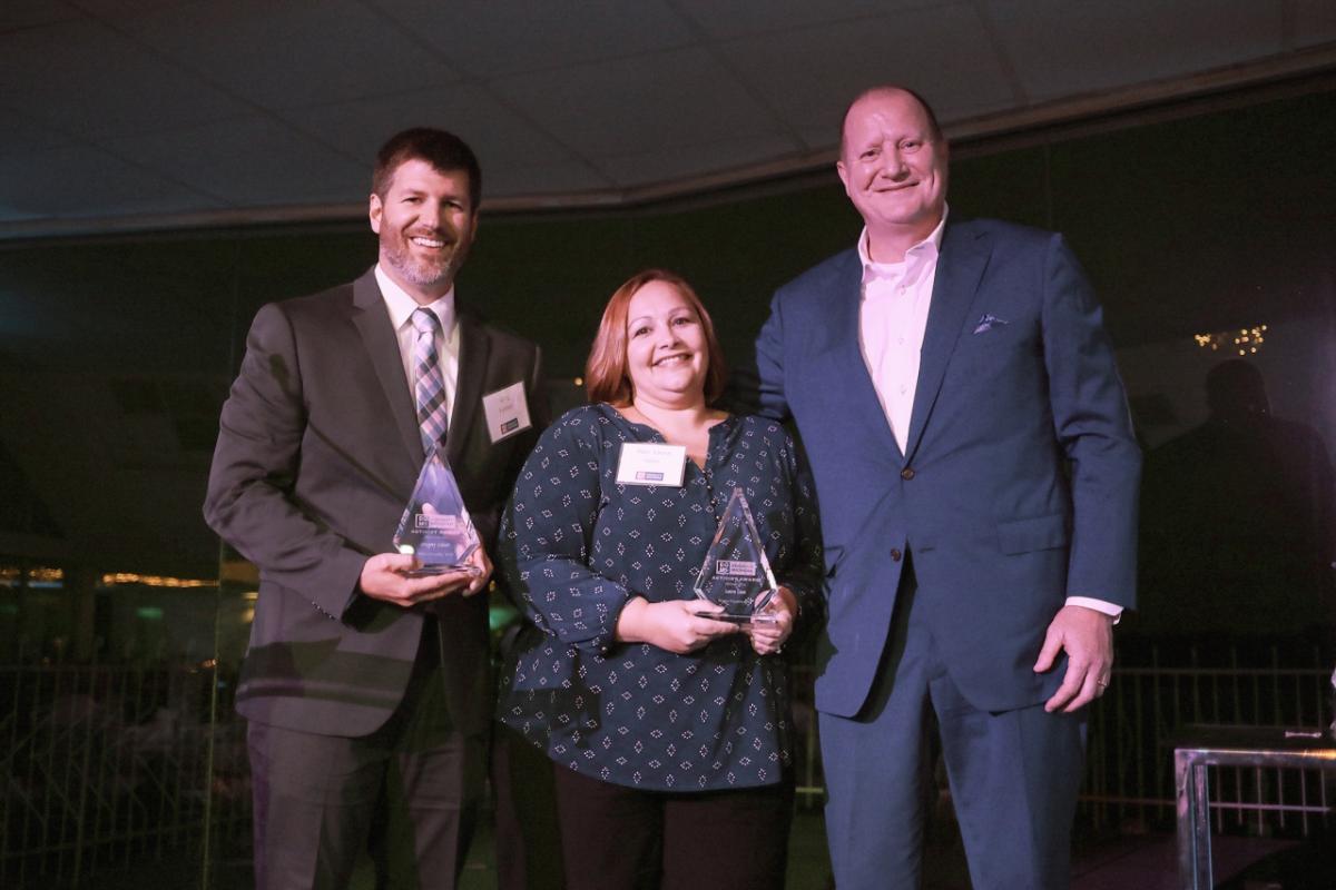 Greg Fulmer (left), Laura Goos (middle) receive their Activist award from Equality Michigan.