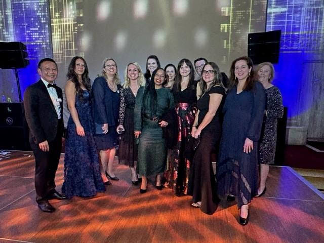 Group of Gala attendees posed on a stage.