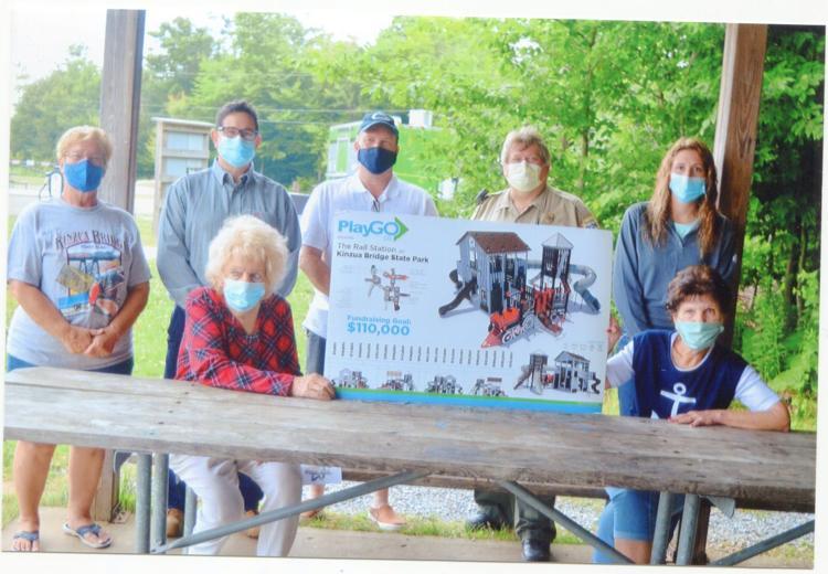 The planned playground for Kinzua Bridge State Park is shown by Mary Ann Burggraf, left, front, and Debbie Kilmer, both with the Kinzua Bridge Foundation, which has been raising funds for the project. From left, standing, are Debbie Lunden with the foundation; Sid Beckwith with Georgia Pacific, which donated to the project; Jeff Wolfe, fundraising chair for the project; Mitch Stickle, park manager; and Heather Meyers from Georgia Pacific. Era photo by Fran De Lancey