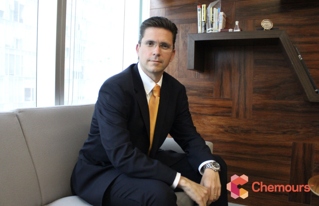 Gerardo Familiar seated in a casual setting, a wood bookcase behind him. Chemours logo in the right corner.