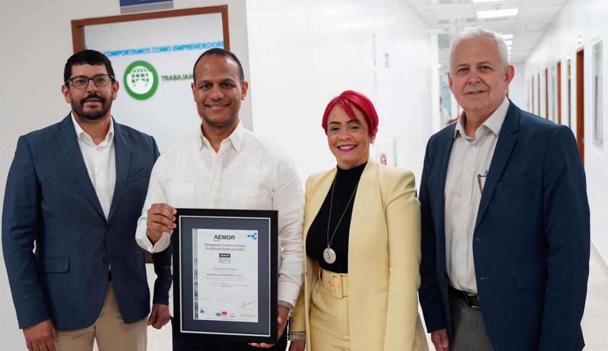 Gildan Achieves ISO 45001 Certification in Two Sewing Factories in the Dominican Republic Four Gildan representative holding Gildan's first ISO 45001 Certification