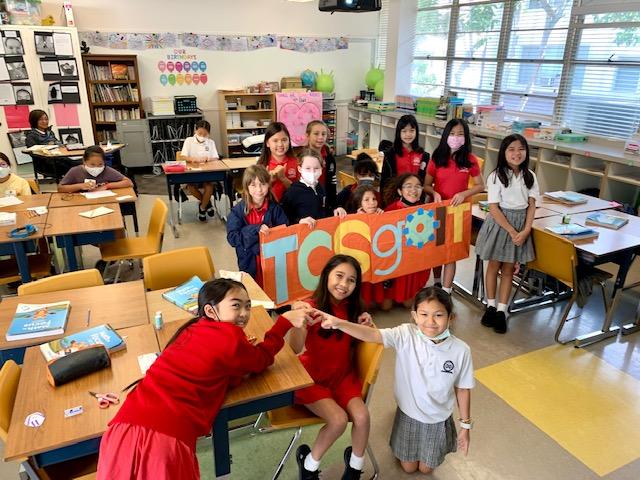 A group of school kids holding TCS goIT sign