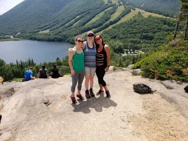 Jenny Oliveira on a hilltop with two other people.