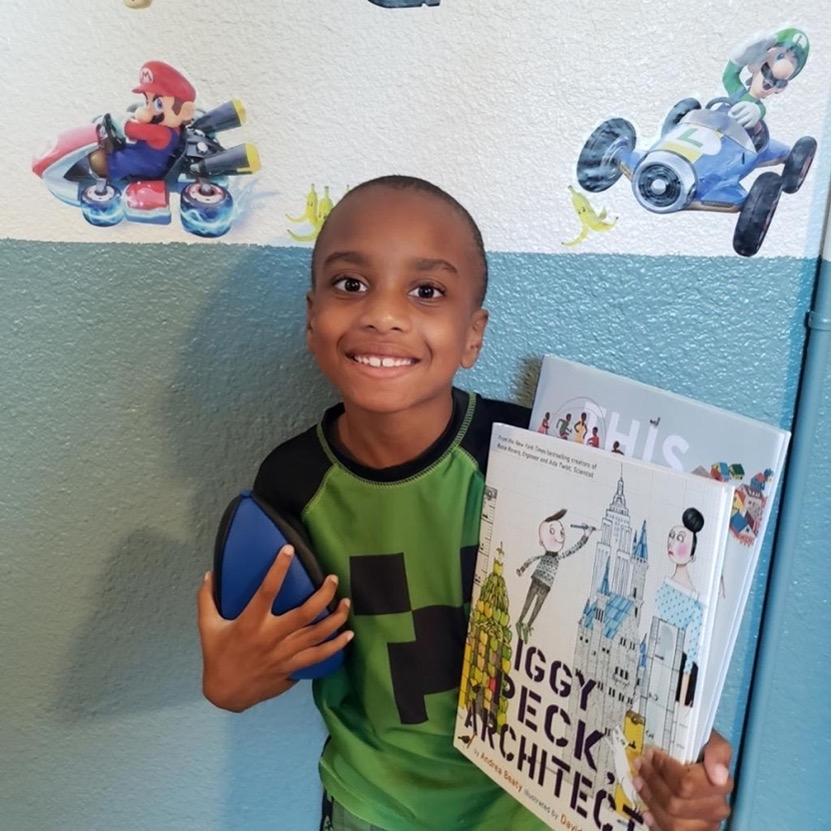 Photo of a young child holding a book.