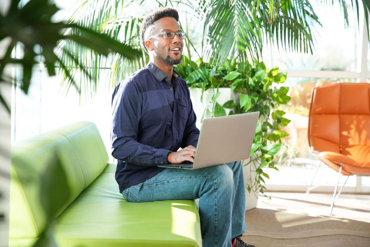 Young person of color seated on a couch.