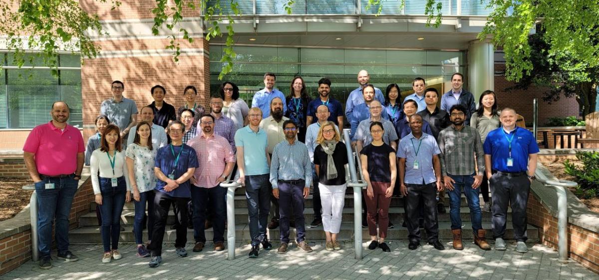 Team of people posed outside a building.