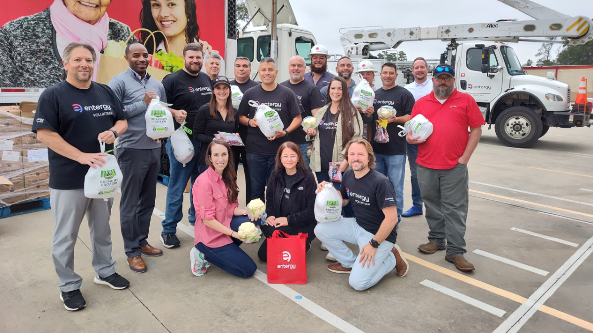 Large group of people holding food donation bags