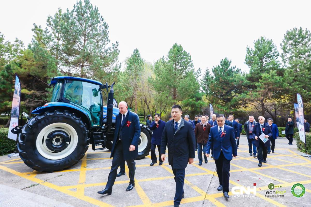 People walking past a CNH tractor into the event