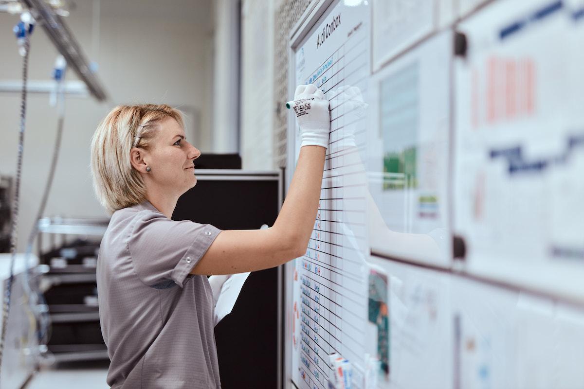 HARMAN employee working on a white board.