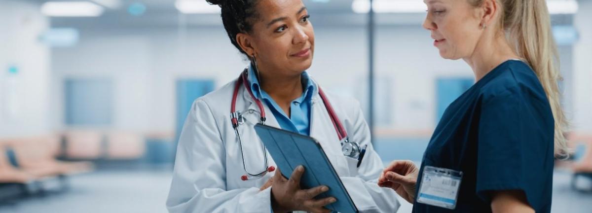 A female doctor speaking with another female doctor.