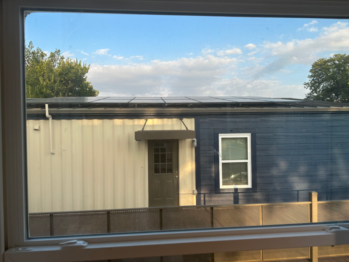 Solar panels seen on the roof of a house through a window 