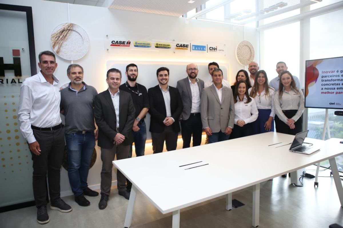 A group of people stood behind a table in an office room