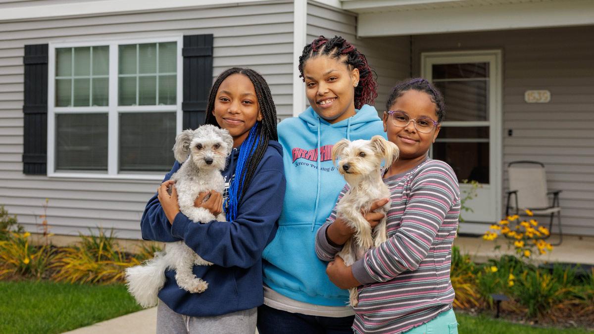 Photo: Ambera Pruitt, center, with her daughters Charity and Azaylia, and two family dogs in front of the home Pruitt purchased five years ago from Habitat for Humanity of St. Joseph County. U.S. Bank volunteers worked alongside Pruitt to help build the home. Ambera Pruitt, center, with her daughters Charity and Azaylia, and two family dogs in front of the home Pruitt purchased five years ago from Habitat for Humanity of St. Joseph County. U.S. Bank volunteers worked alongside Pruitt to help build the home.