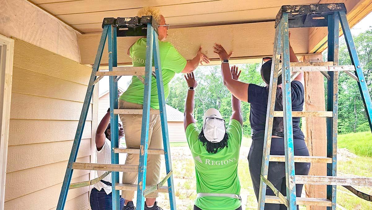 3 people constructing a house
