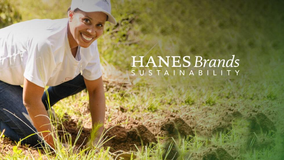 A photo of a woman planting a tree in a field.