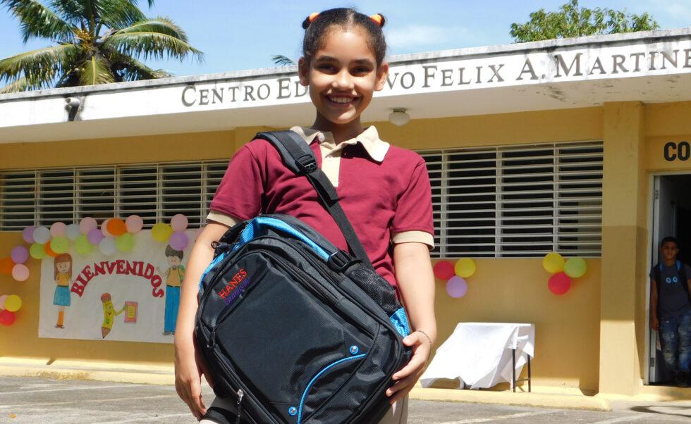 Young student in front of a school in Latin America.