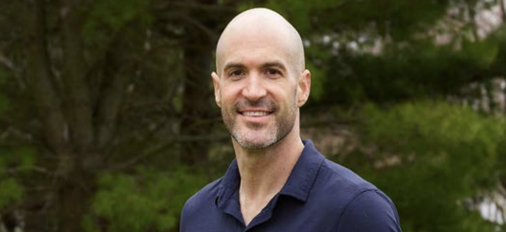 Headshot of a person stood in front of a tree