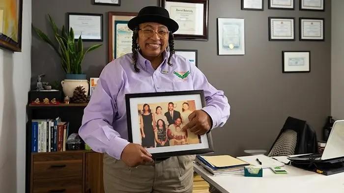 Helen Mathis holding up a family photograph