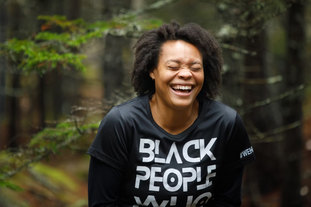 person laughing in front of tree