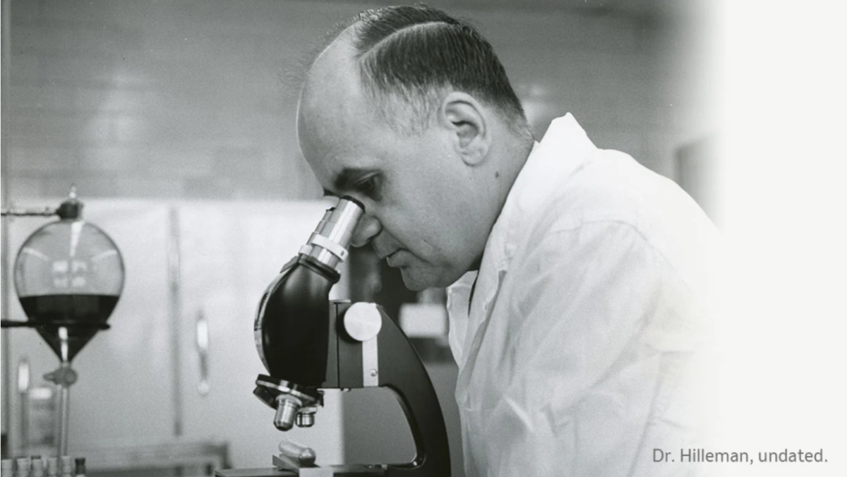 black and white photo of Dr. Hilleman looking in a microscope