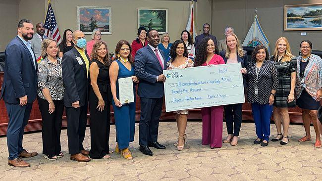 Group holding an award and large check from Duke Energy