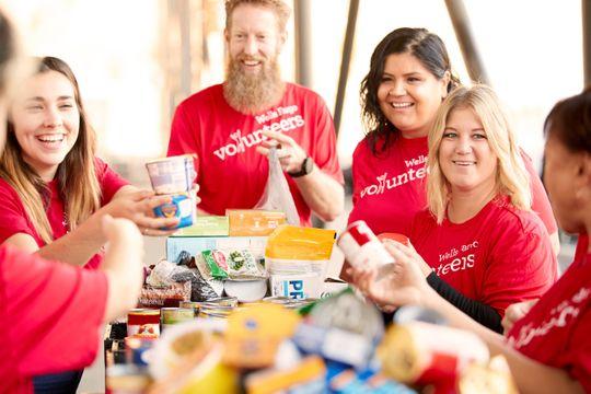 Wells Fargo team members roll up their sleeves to fight hunger at a food bank.