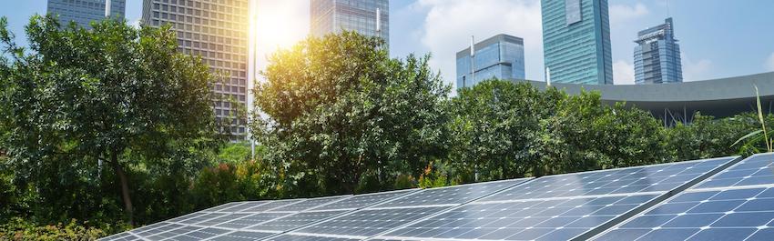 Solar panels shown against rising sun.