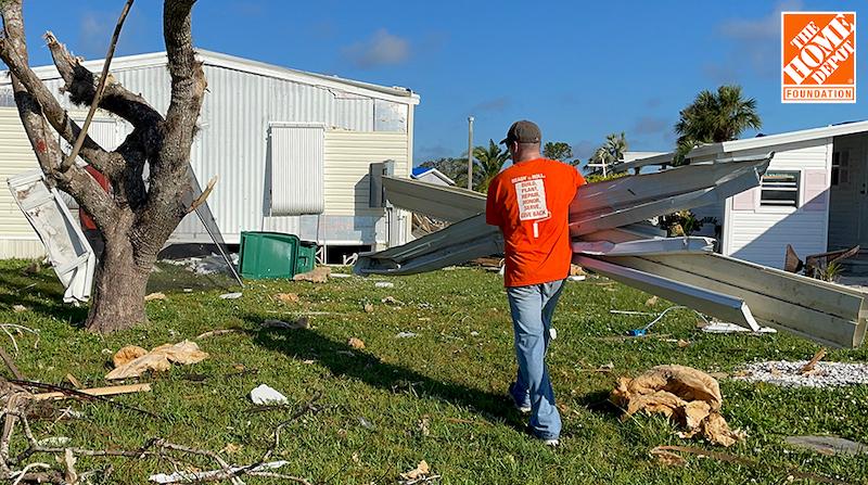 Home Depot volunteer shown cleaning up after Hurricane Ian.