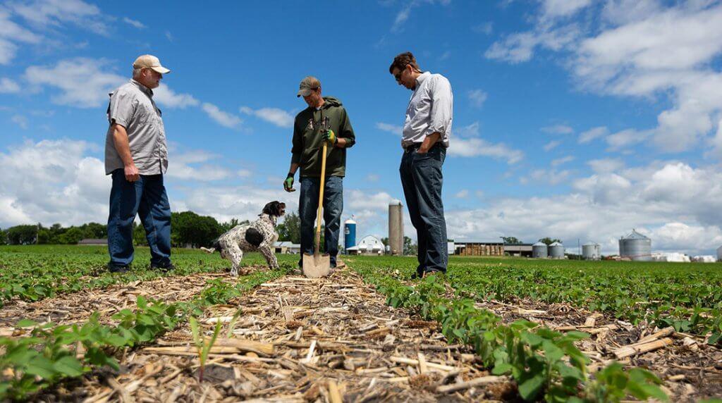 group of farmers standing in field