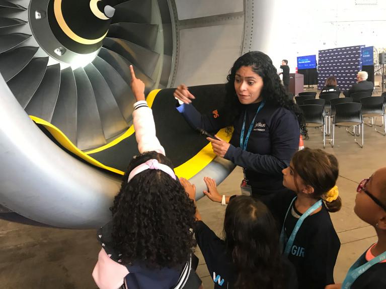 JetBlue mechanic Katia de Souso de Melo shows a group of girls how jet engines work in JetBlue’s hanger at Logan Airport in Boston on Saturday, Oct. 12, 2019.