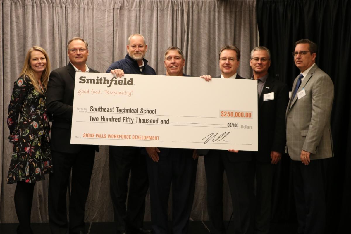 Smithfield Foods presents a check for $250,000 to Southeast Technical Institute during the South Dakota Chamber of Commerce Economic Outlook Seminar on Oct. 1.
