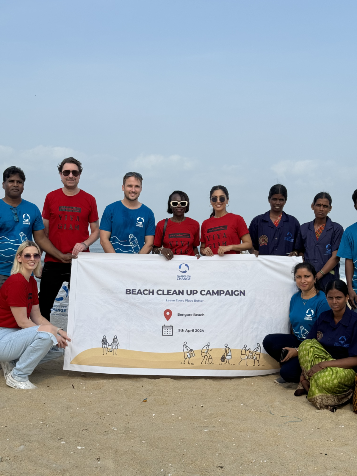 Volunteers pose with Beach clean up campaign banner