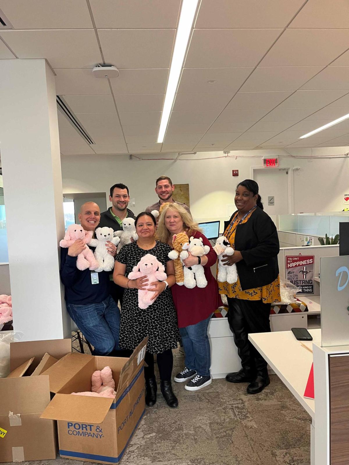 Covia employees pose with teddy bears for charities and hospitals