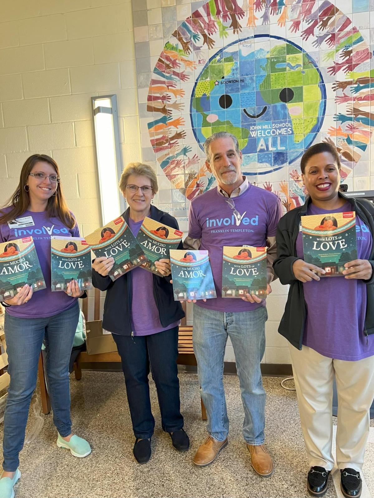 Four Short Hills volunteers holding up books