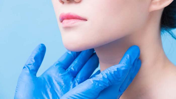 Japanese woman having a test done on her neck. Hands showing how a nasopharyngeal carcinoma is detected. 