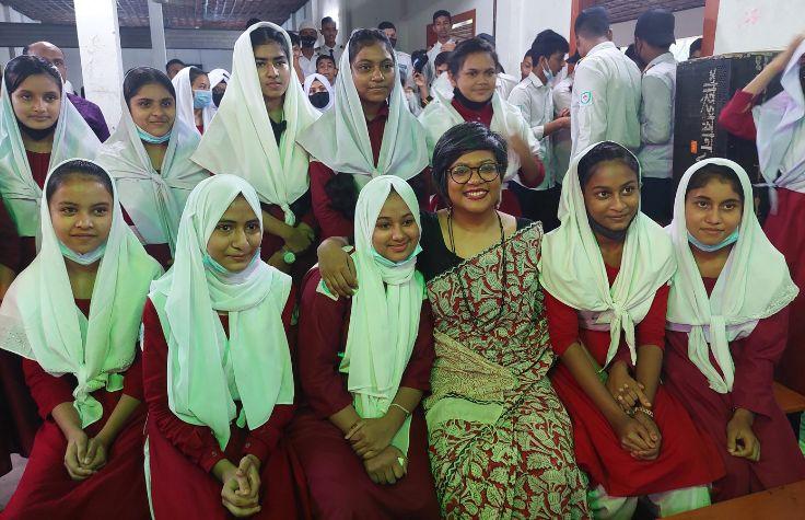 Students shown with their teacher at a presentation.