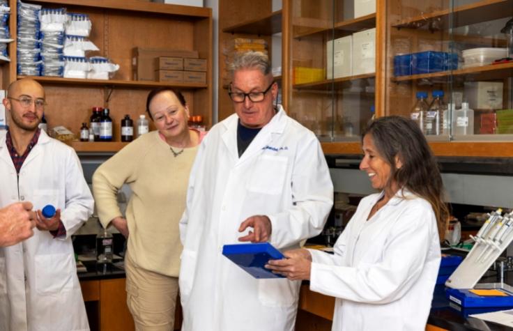 Drs. Johnston and Mandel with a box containing microscope slides for pathology samples. 