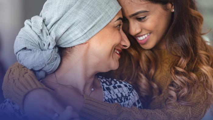 Female cancer patient hugging a young girl.