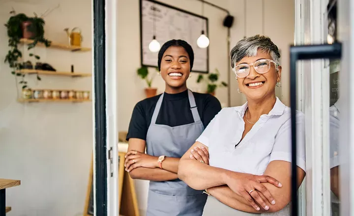 Two people smiling, standing with arms crossed