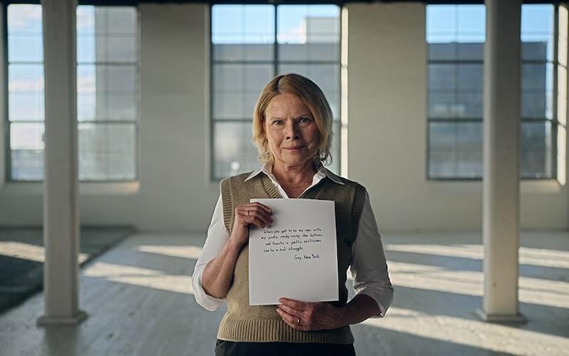 A woman holding a sheet of paper in an office space.