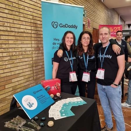Cécile Vivares shown with GoDaddy coworkers at a trade show booth.