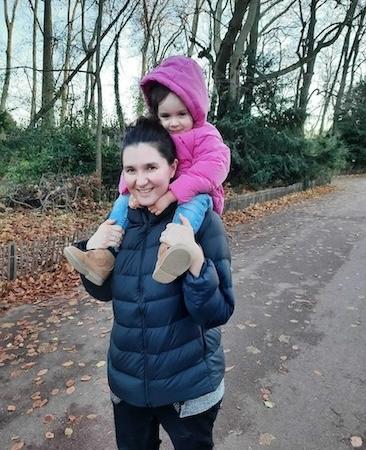 Cécile Vivares with her daughter who is riding on her shoulders.