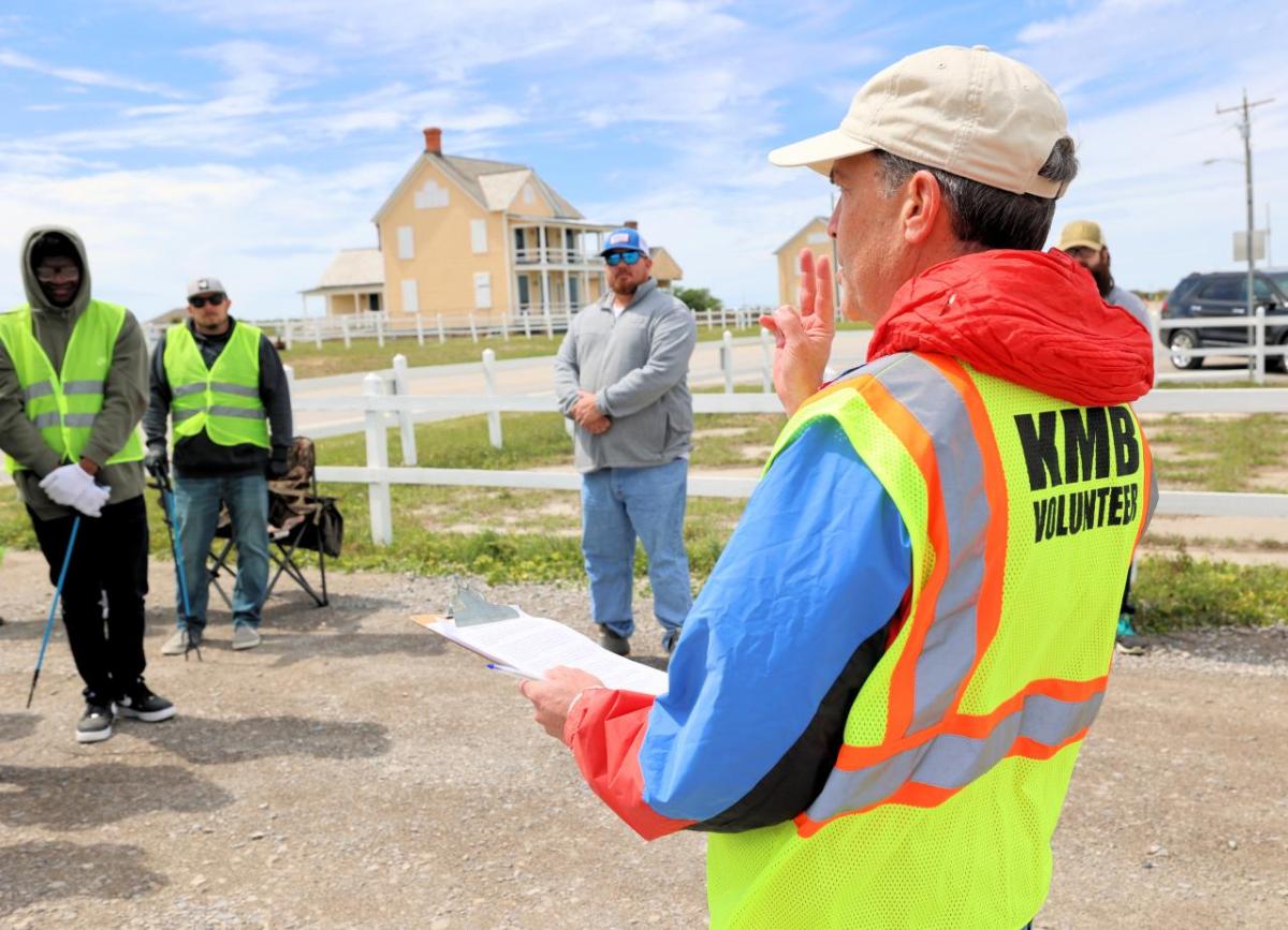 AEG employees and fans receive instruction at the Fort Morgan clean-up.